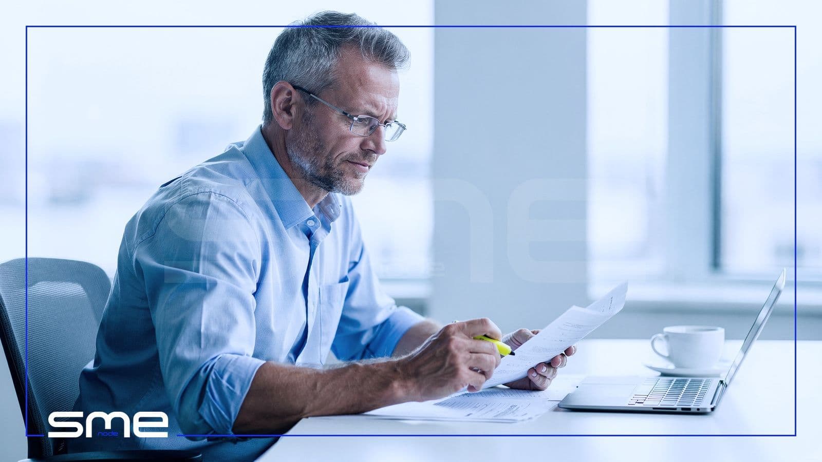 A chief financial officer reviewing a printed IT roadmap register with a highlighter at a bright office desk