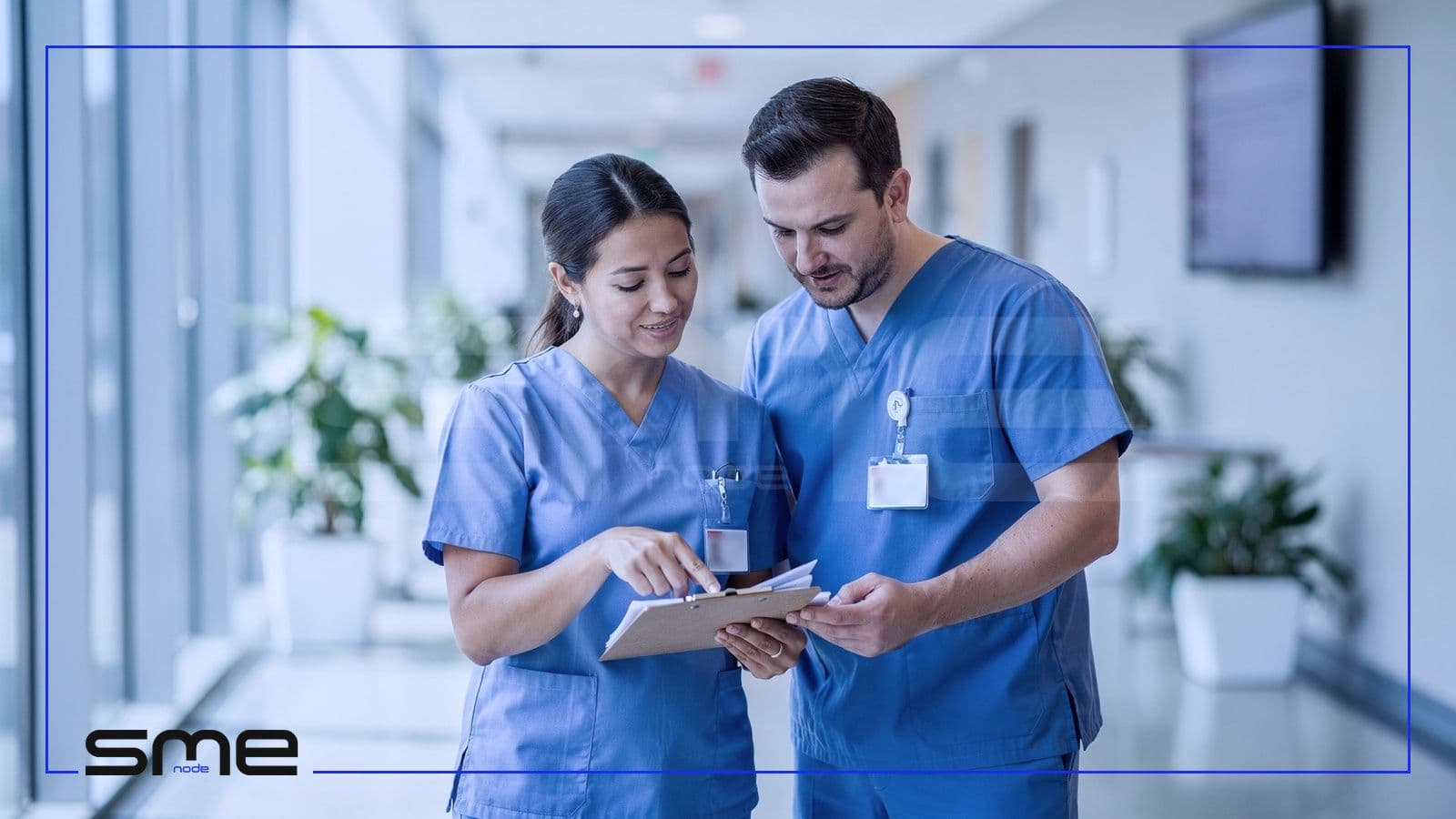 A physician and a nurse in scrubs reviewing a paper patient chart in a bright Canadian clinic hallway, the people Canadian health privacy law protects and binds