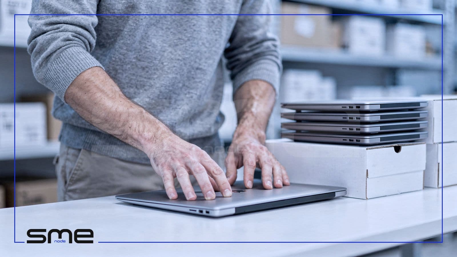 An IT technician preparing a stack of new laptops on a workbench to replace Windows 10 PCs before the security update deadline