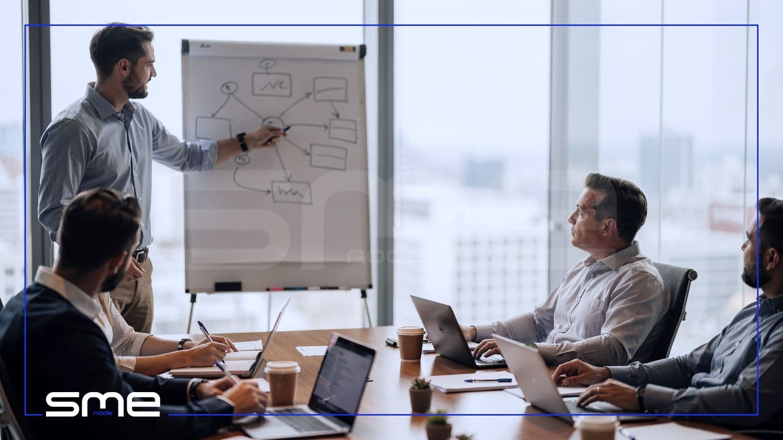 Security architect sketching a network diagram on a flip chart for a client team in a boardroom