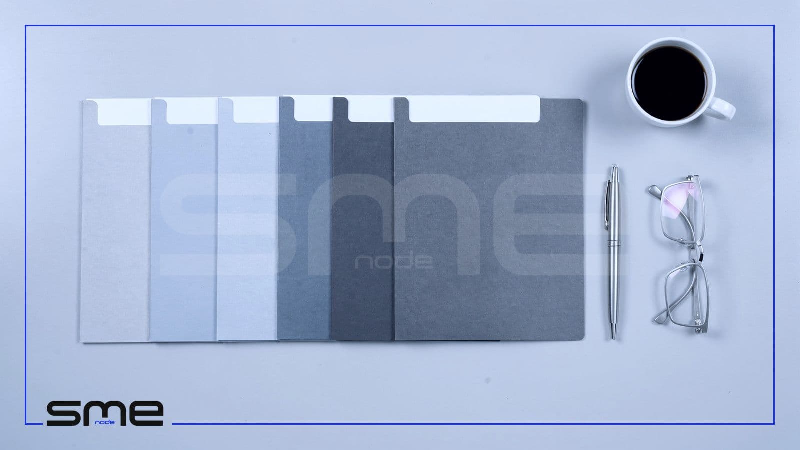 A row of blank tabbed document folders laid out on a light desk beside a pen and reading glasses, representing the deliverables of an AI strategy consulting engagement